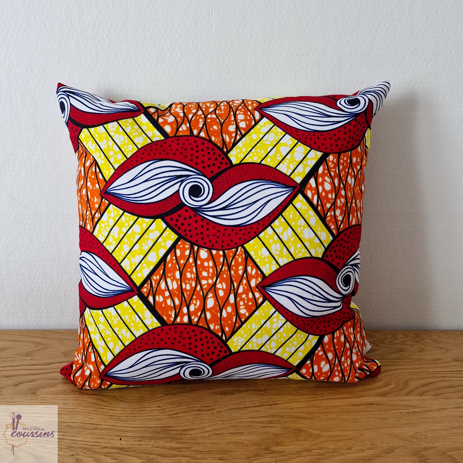 coussin en wax motifs géométrique en rouge, jaune, orange les ptits coussins