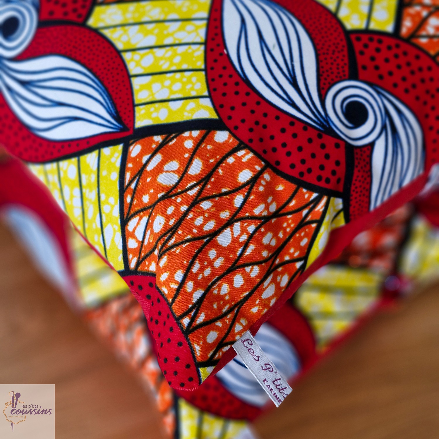 coussin motifs géométrique en rouge, jaune, orange et blanc les ptits coussins